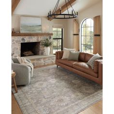 a living room filled with furniture and a fire place in the middle of an open floor plan