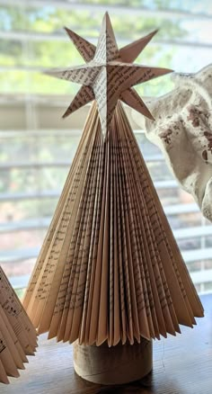 an origami christmas tree made out of book pages sitting on top of a table