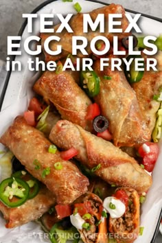 Tex Mex Egg Rolls topped with jalapeños, olives and tomatoes with a title. Ground Beef Egg Rolls Air Fryer, Ground Beef Egg Rolls Recipes, Taco Egg Rolls Air Fryer, Egg Roll Wrapper Recipes Dinners, Taco Egg Rolls Ground Beef, Homemade Egg Roll Wrappers, Egg Roll Wrapper Recipes Air Fryer, Ground Beef Egg Rolls, Meat Air Fryer