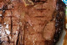 a piece of steak on a green and white plate with blue flowered design around it