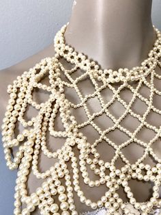 "Pretty faux pearl necklace with all over beads to dress up any look. Beads create a cross cross and drape loop design down the front. Adjustable clasp and chain in gold toned and variety of size beads Measurements: Bib front is 10\" long by 10\" to 5\" wide from top to bottom" Beaded Pearl Necklaces For Party, Pearl Beaded Necklaces For Party, White Pearl Chain Backdrop Necklace For Party, White Beaded Backdrop Necklace For Evening, Party Backdrop Necklace With White Pearl Chain, Party White Backdrop Necklace With Pearl Chain, Evening White Beaded Backdrop Necklace, White Beaded Pearl Bib Necklace, White Pearl Beaded Bib Necklaces