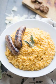 two sausages on top of rice in a white bowl