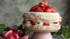 two strawberries sit on top of a cake