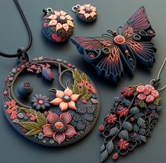 three necklaces and two pendants are shown with flowers, butterflies, and leaves