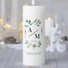 a candle that is sitting on a table with some candles in the background and an am sign next to it