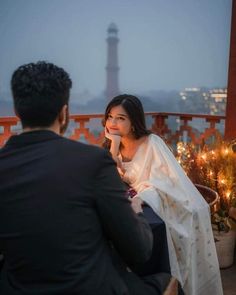 a man sitting next to a woman on top of a roof