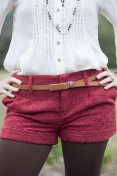 These red textured shorts feature two front pockets, two buttoned back pockets, a front zipper and double hook closure, cuffs, front pleats, and belt loops. Fitted Bottoms With Belt For Day Out, Red Bottoms With Belt Loops And Short Length, Short Bottoms With Belt Loops For Fall, High-waisted Shorts With Belt Loops For Fall, Red Shorts With Belt Loops, High Waist Shorts With Belt Loops For Fall, Fall High Waist Shorts With Belt Loops, Short Fall Bottoms With Belt Loops, Fall Season Belted Short Bottoms