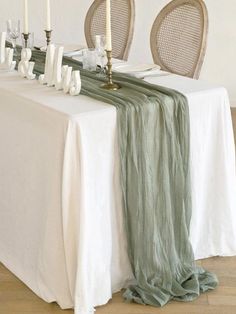 the table is set with white and green linens