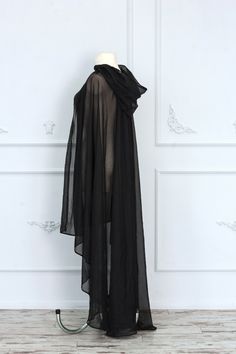 Gorgeous sheer black hooded cape made of tulle. It will make every your look mysterious and luxurious. The cape will be perfect for complementing your fantasy or gothic dress. It is possible to recreate this cape with other materials and coloring, just write to us, and we will choose the best fabric special for you. The standard back length is 55 inches (140 cm). If you want more or less, please, write to us. ♥See all cloaks and capes: https://etsy.me/2Qkhon8 =SHIPPING= We provide Standart airma Cheap Black Cosplay Costumes, Black Sparkly Hooded Shawl, Luxury Medieval Cape For Cosplay, Luxury Black Gothic Cosplay Costume, Luxury Black Cape For Costume, Luxury Black Cape For Costume Party, Landscape Fabric For Witches Cape, Elven Cape Dress, Long Black Wizard Robe