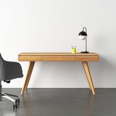 an office desk with a chair next to it and a lamp on the table in front of it