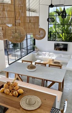 a dining room table with some food on top of it and lights hanging from the ceiling