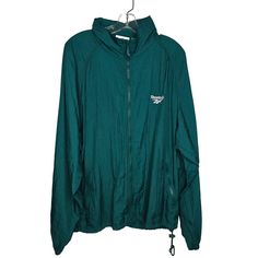 This vintage Reebok windbreaker jacket features a hood, ensuring protection against the elements. The lightweight nylon material and vibrant green color evoke a sense of classic athletic style. * Full front zip closure * Drawstring hem * Zippered pockets * Mesh interior lining * Embroidered Reebok logo Has a faint mark at the right armpit. Color is the most accurate on the photos of logo close ups. Size: Mens L Condition: Pre-Owned Good Green Windproof Windbreaker For Streetwear, Green Nylon Track Jacket For Hiking, Green Sportswear Windbreaker For Outdoor, Green Nylon Track Jacket For Outdoor Activities, Sporty Green Windproof Windbreaker, Green Sporty Windproof Windbreaker, Sporty Green Windbreaker For Outdoor Activities, Green Windproof Sporty Windbreaker, Green Windproof Sporty Track Jacket