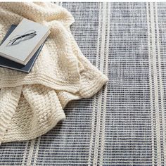 a book is laying on top of a blue and white blanket with a feather drawn on it