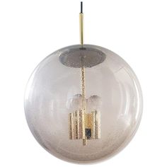 a clear glass ball hanging from a gold colored metal rod