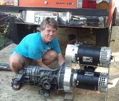 a man kneeling down next to an engine