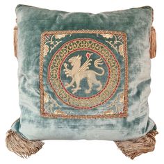 a blue pillow with a lion on it's side and tassels around the edges