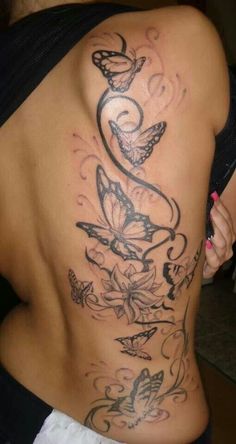 a woman's back with butterflies and flowers on it