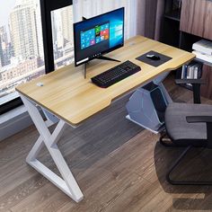 a computer desk with a keyboard, mouse and monitor sitting on it in front of a window