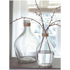 two glass vases with flowers in them on a table