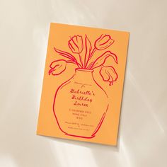 a yellow birthday card with red flowers in a vase on top of a white surface