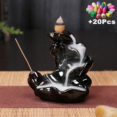 a black and white incense burner on top of a mat with a stick sticking out of it