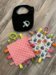 two baby bibs, one black and one pink with owls on them