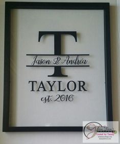 a framed sign with the name and date on it in black, white and gray