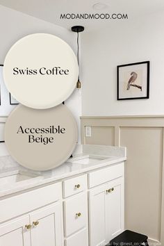 a bathroom with white cabinets and two round signs on the wall that say, swiss coffee accessible feege