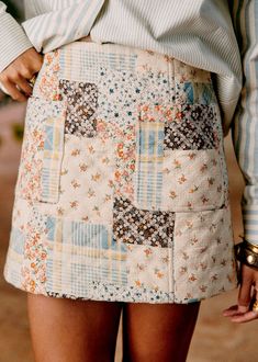 a close up of a woman's skirt with patches and flowers on the side