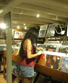 a woman looking at records in a record store