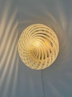 a light that is sitting on the wall next to a white wall with some lights in it