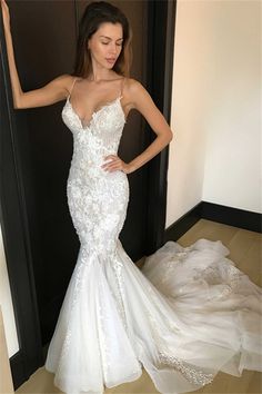 a woman in a white wedding dress standing next to a doorway with her hand on her hip