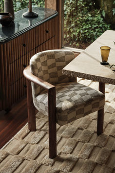 a chair sitting on top of a rug next to a table