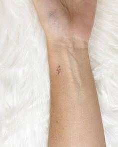 a woman's arm with a small tattoo on it, and the number four