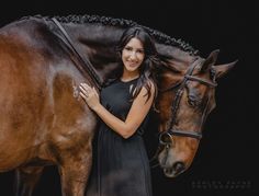 a beautiful woman standing next to a brown horse