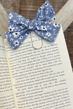 an open book with a blue bow on it