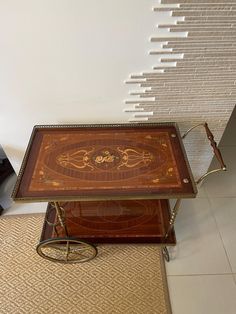 a wooden table sitting on top of a tiled floor next to a clock and shelf