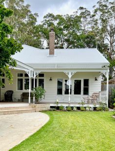 a white house sitting on top of a lush green field