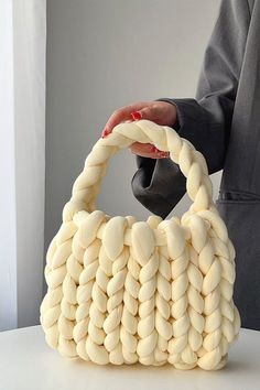 a person holding a white bag made out of small round objects