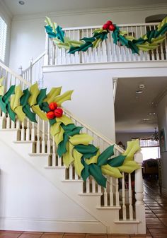 a decorated christmas garland on the bannister of a house in front of stairs