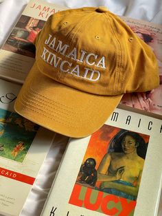 Jamaica Kincaid  Womb House Books Hat  Adjustable cotton hat Mustard yellow color JAMAICA KINCAID on front Womb House Books on back Ships in approximately four weeks Yellow Cotton Dad Hat, Yellow Cotton Curved Brim Dad Hat, Yellow Cotton Dad Hat With Curved Brim, Yellow Cap For Vacation, Yellow Cotton Dad Hat, One Size Fits Most, Yellow Vacation Cap, Yellow Cotton Hat (one Size Fits Most), Adjustable Yellow Cotton Hat, Yellow Wide Brim Cotton Hat