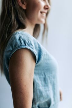 a close up of a person wearing a blue shirt and holding something in her hand