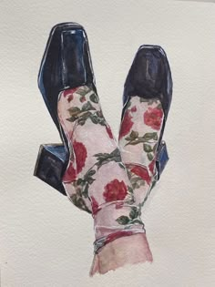 a watercolor painting of a pair of shoes with roses on them and the bottom part of the shoe