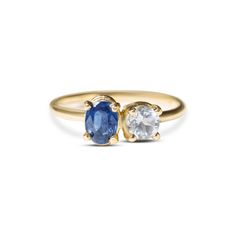 two gold rings with blue and white stones on the sides, one has an oval shaped sapphire