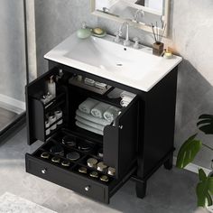 a bathroom sink sitting under a mirror next to a cabinet filled with towels and other items