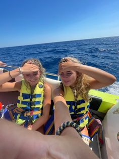 two girls in life jackets on a boat