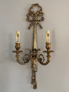 a wall mounted light with two candles on it