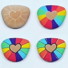 four colorful rocks with hearts painted on them