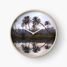 a clock with palm trees reflected in the water