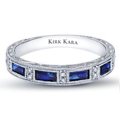 a white gold band with blue sapphires and diamonds on the sides, set in 18k